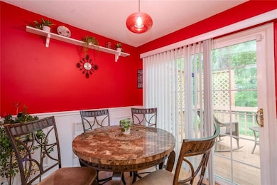 Dining area featuring a wainscoted wall, a decorative wall, and a textured ceiling