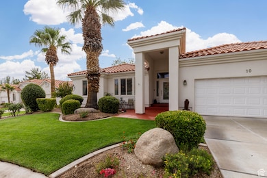 Mediterranean / spanish house with a front lawn, driveway, a tiled roof, stucco siding, and a garage