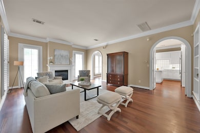 Another view of spacious Living room with elegant arched entries into the Kitchen & Dining room.