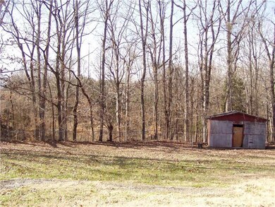 View of back of the property.  Most of back yard in fenced in.  This is the 2nd storage building-needs a little TLC. 