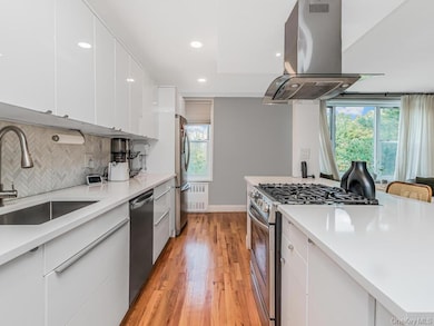 Kitchen featuring white cabinetry, island range hood, appliances with stainless steel finishes, modern cabinets, and recessed lighting