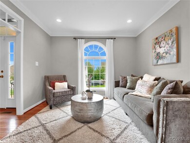 Living room featuring ornamental molding and hardw