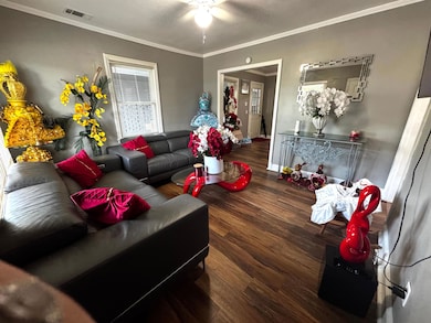 Living area with ornamental molding, wood finished floors, and ceiling fan