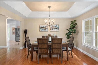 Dining room has hardwood flooring, coffered ceilin