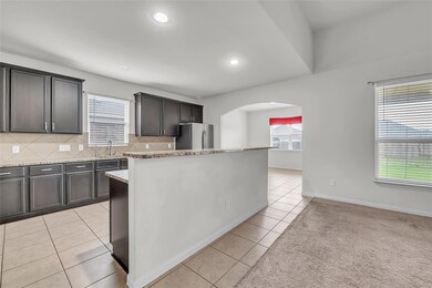 Kitchen featuring freestanding refrigerator, arch