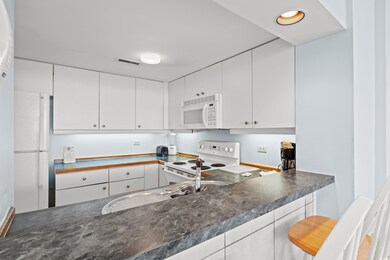 Kitchen featuring white cabinets and white applian