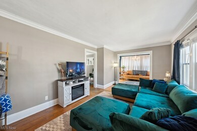 Living room featuring plenty of natural light, light hardwood / wood-style flooring, and crown molding