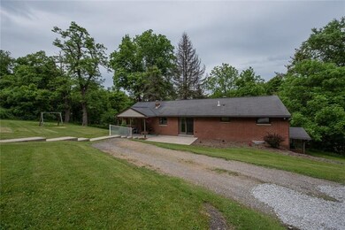 Brick home surrounded by acres of trees and entert