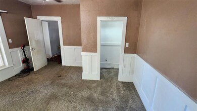 Unfurnished bedroom with dark colored carpet
