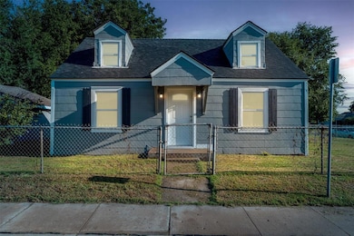 Cape cod-style house with a gate, a fenced front yard, and a shingled roof