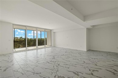 Open living space featuring tray ceiling and light marble flooring