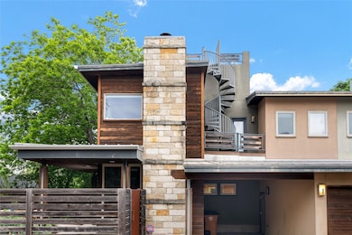 Back of property featuring a balcony, a chimney, 