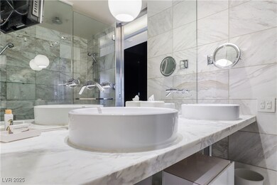 Full bath with tile walls, a shower, and a sink