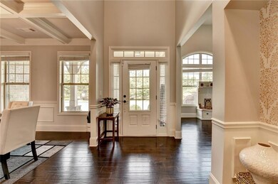 Foyer featuring plenty of natural light, hardwood / wood-style floors, wainscoting, beam ceiling, and coffered ceiling