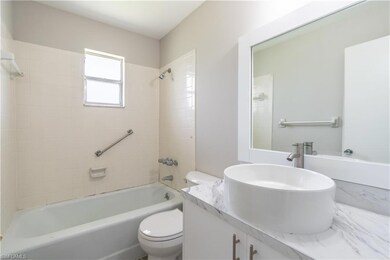 Full bathroom with tiled shower / bath combo, vani