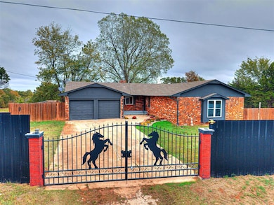 Ranch-style house with a fenced front yard, brick siding, a garage, and driveway