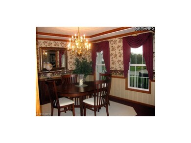 The dining room is elegant with crown molding, cha
