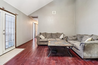 Living room featuring dark wood-style floors and high vaulted ceiling