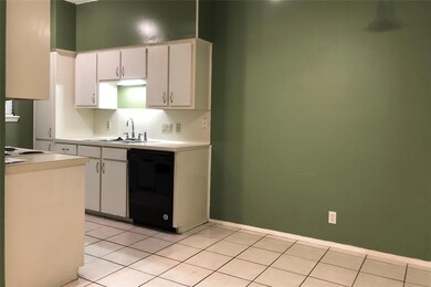 Kitchen with dishwasher, light countertops, a sin