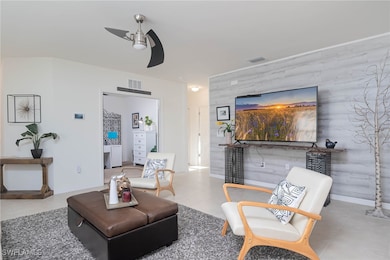 Living room with ceiling fan and wood walls