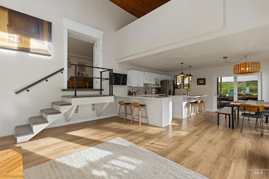 Kitchen featuring a breakfast bar, light countertops, a peninsula, light wood finished floors, and white cabinetry