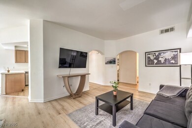 Living area with arched walkways, baseboards, visi