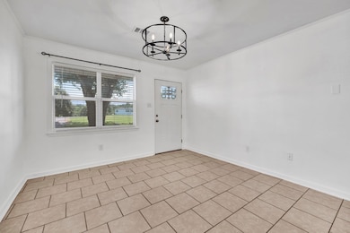 Unfurnished dining area featuring a chandelier and baseboards