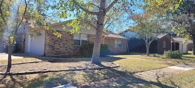 View of front of house with brick siding and a front lawn