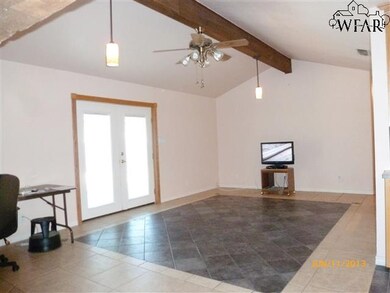 Tiled living room has decorative ceiling beam, ful