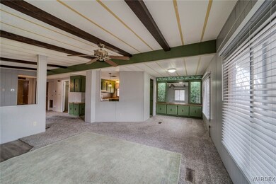 Unfurnished living room featuring ceiling fan, bea