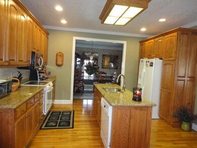 Another view into this beautiful kitchen. This kitchen has hardwood flooring and an abundant amount of cabinet storage and a built in pantry.