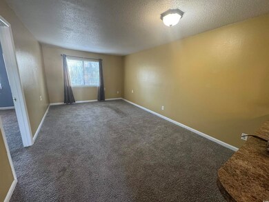 Empty room featuring a textured ceiling, carpet fl