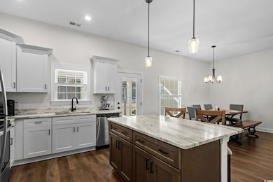 Kitchen with white cabinetry, dark brown cabinetry, light stone countertops, dark wood-style flooring, and recessed lighting