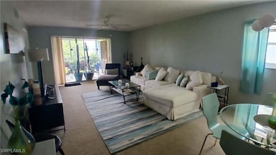 Carpeted living room with ceiling fan