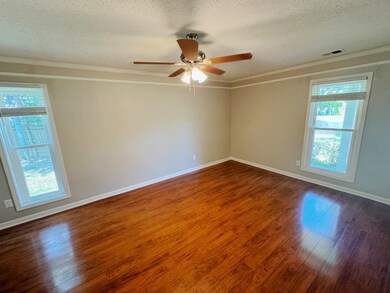 Empty room with a textured ceiling, dark wood-type