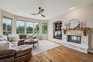 Living room featuring baseboards, a ceiling fan, 