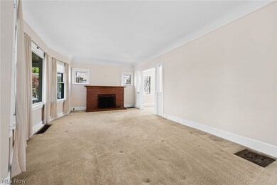 Unfurnished living room with carpet floors and a brick fireplace