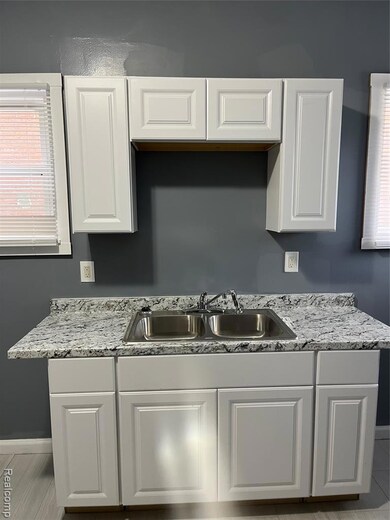 Kitchen featuring plenty of natural light, white cabinets, and light tile patterned floors