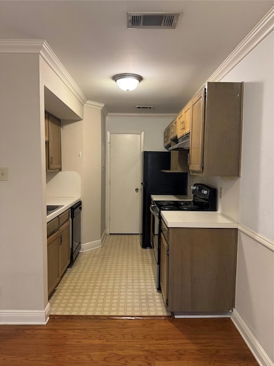 Kitchen with ornamental molding, range, light wood-style flooring, light countertops, and dishwasher