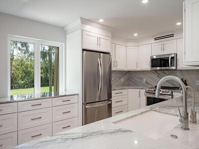 Kitchen featuring light stone counters, sink, whit