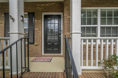 View of exterior entry with brick siding and covered porch