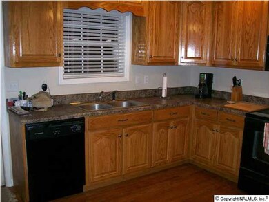 Another view of the kitchen with wood floors