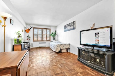Bedroom featuring baseboards and radiator heating unit