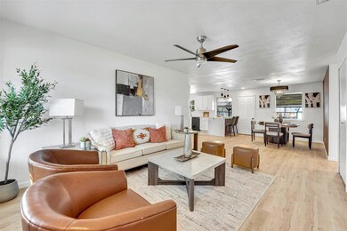 Living room with a textured ceiling, light hardwoo