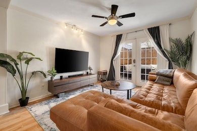 Living room with crown molding, baseboards, wood f