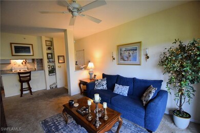 Carpeted living area with ceiling fan
