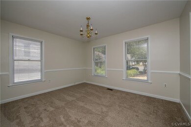 dining room with chair rail, chandelier, and carpe