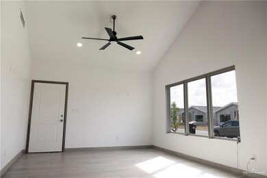 Spare room with light hardwood / wood-style flooring, high vaulted ceiling, and ceiling fan