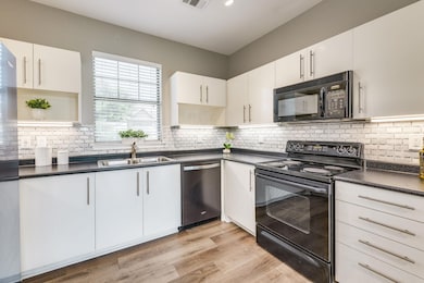 Kitchen with black appliances, open shelves, a si