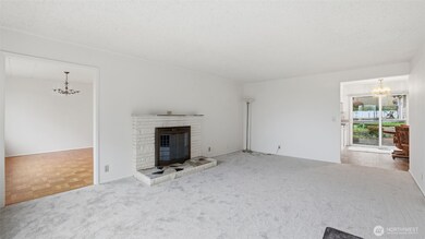 Open and airy living room with sweeping natural light and a welcoming focal-point fireplace.
